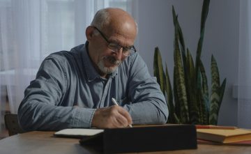 Homme âgé assis à son bureau, travaillant